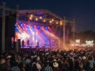 Show ao vivo em arena de rodeio à noite com iluminação de palco e público no São Carlos Rodeio Fest